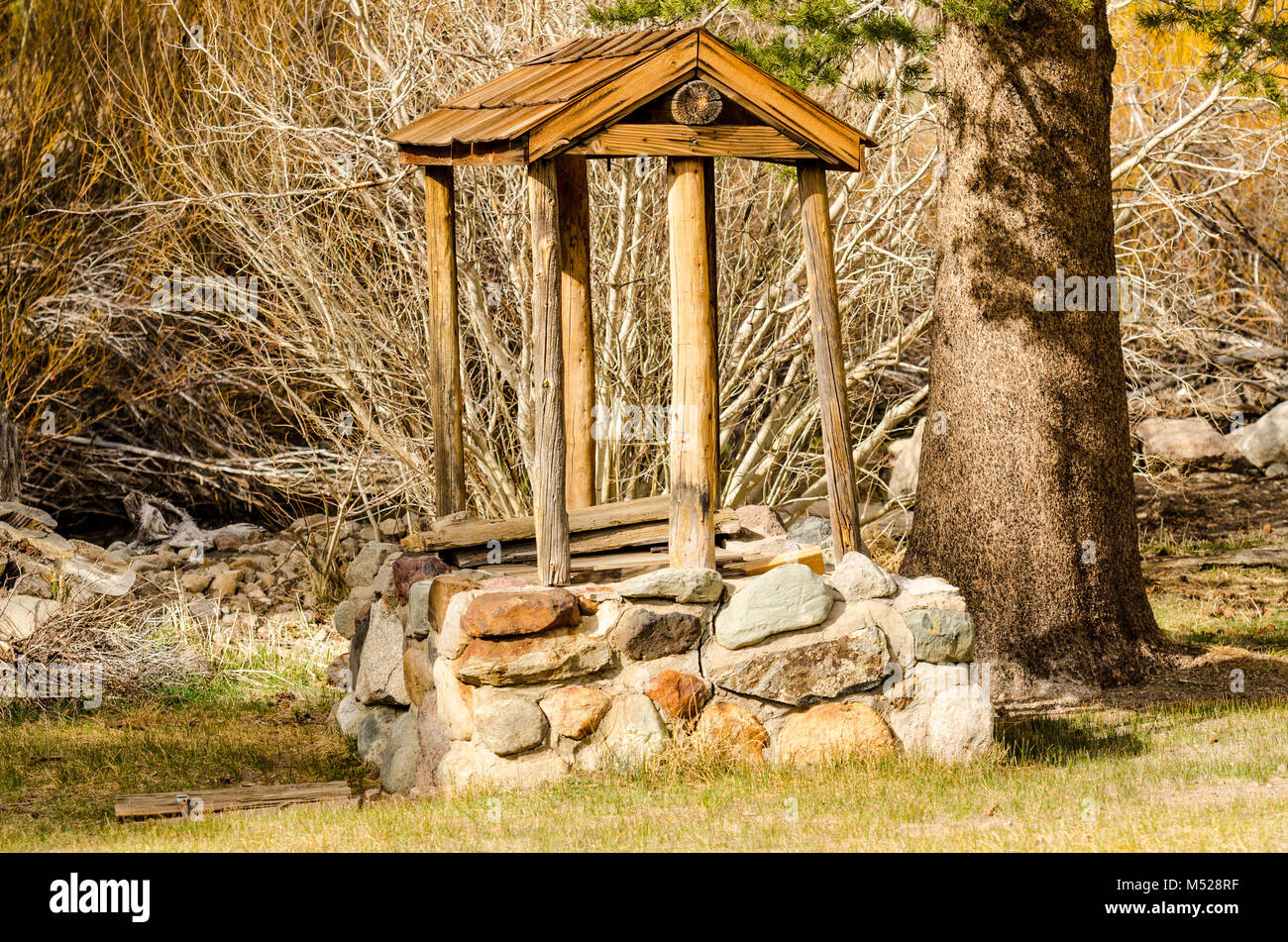 Wood and stone well on historic site of Hayden Log Cabin in Mammoth Lakes, California. Stock Photo