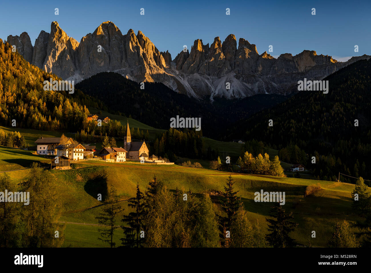 Peaks of the Odle group with village St. Magdalena in autumn in the ...