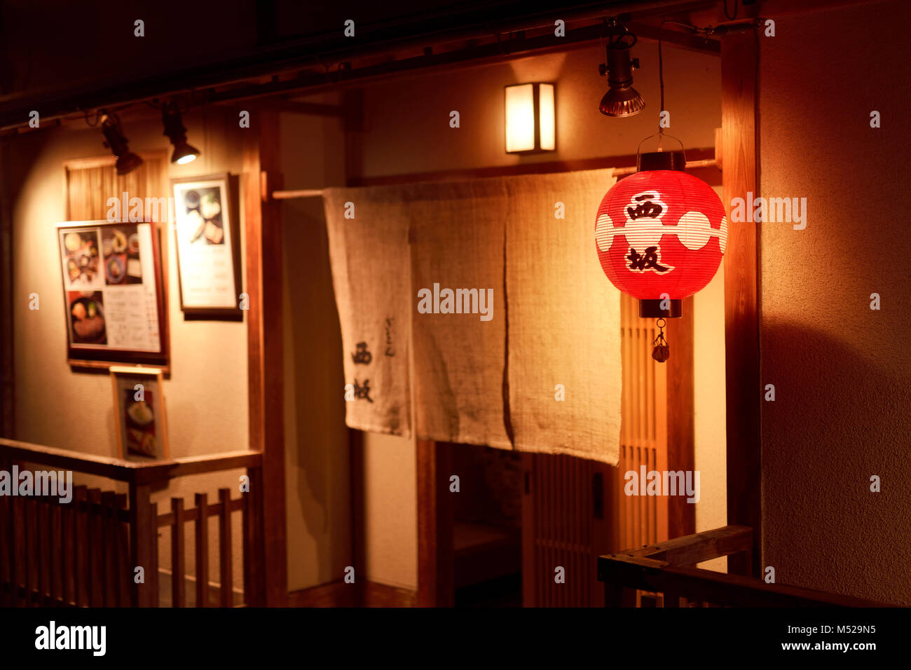 Gion Nishizaka, traditional Japanese restaurant entrance door with a Noren curtain lit up by a lantern at night. Hanamikoji Dori street in Gion distri Stock Photo