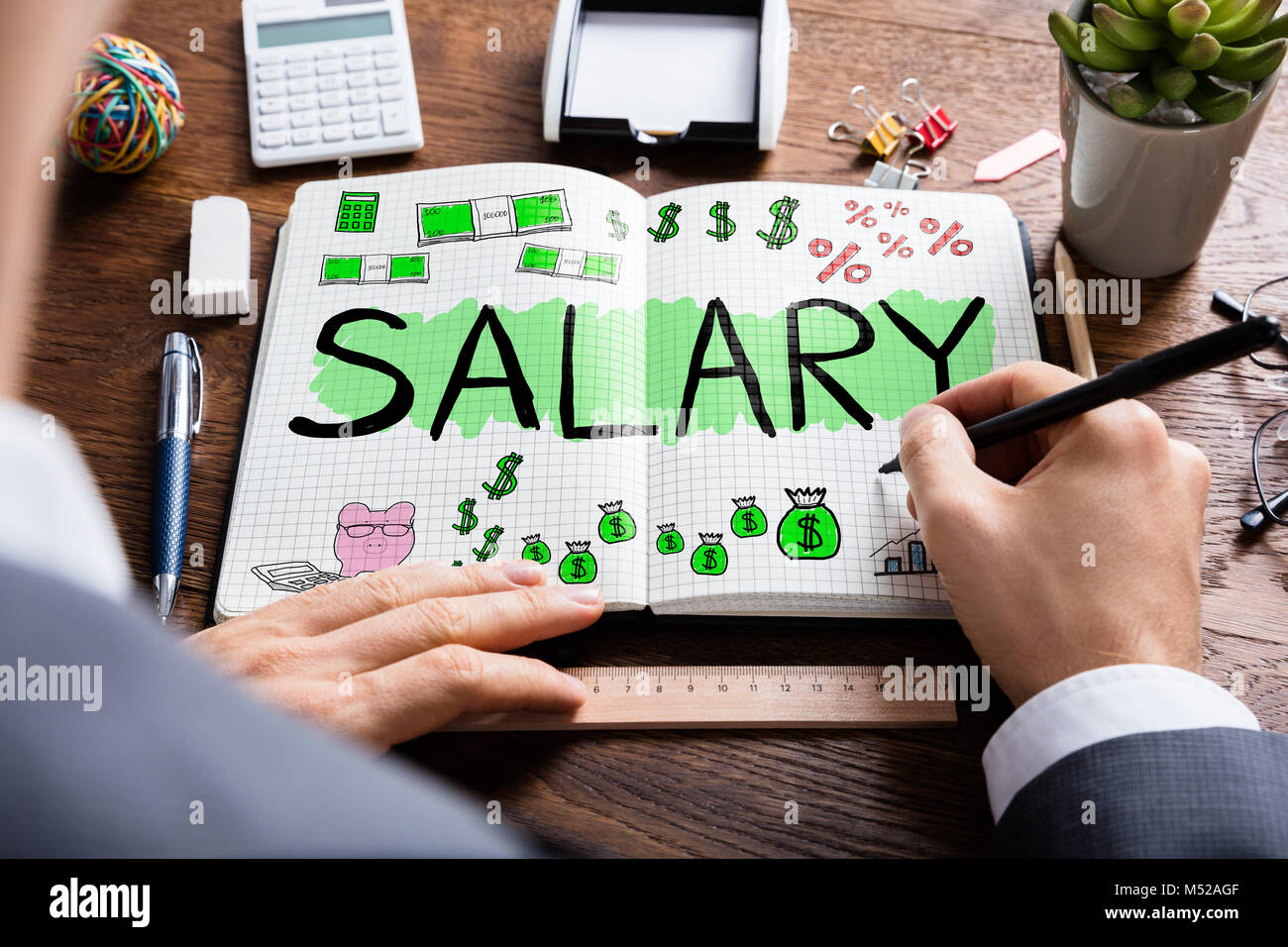 Man Drawing Salary Word In Notebook At Desk Stock Photo 175229167