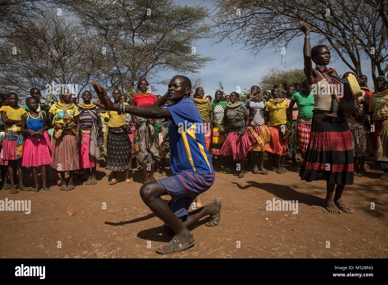 A man from the Pokot tribe dances in front of a line of females close to Katobua village in Karamoja, northern Uganda. Stock Photo