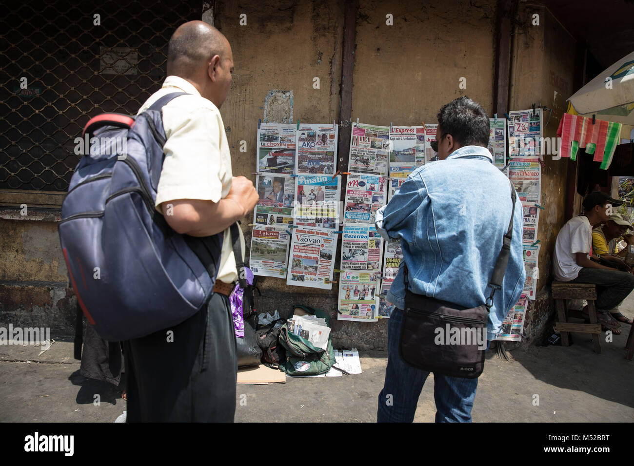 Madagascans read newspaper front pages in central Antananarivo. Many cannot afford to buy the full paper, but it still provides them with essential information about the plague outbreak. Madagascar is suffering from its worst plague outbreak in at least 50 years. Stock Photo