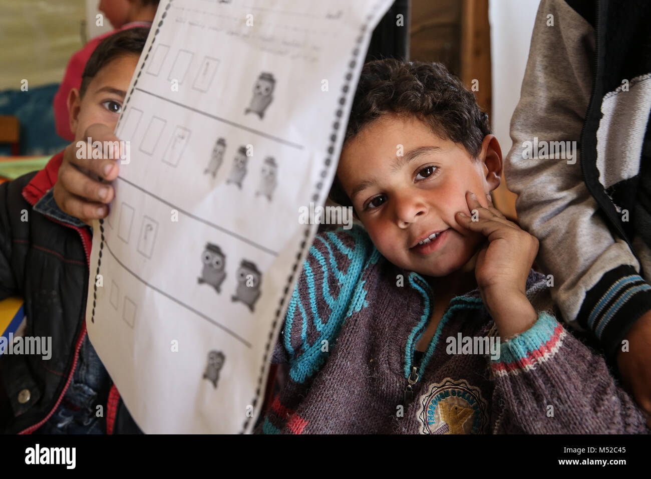 Syrian children show off their schoolwork in a refugee camp in Bekaa Valley. More than one million Syrians fled to Lebanon after the Syrian war began in 2011. Stock Photo