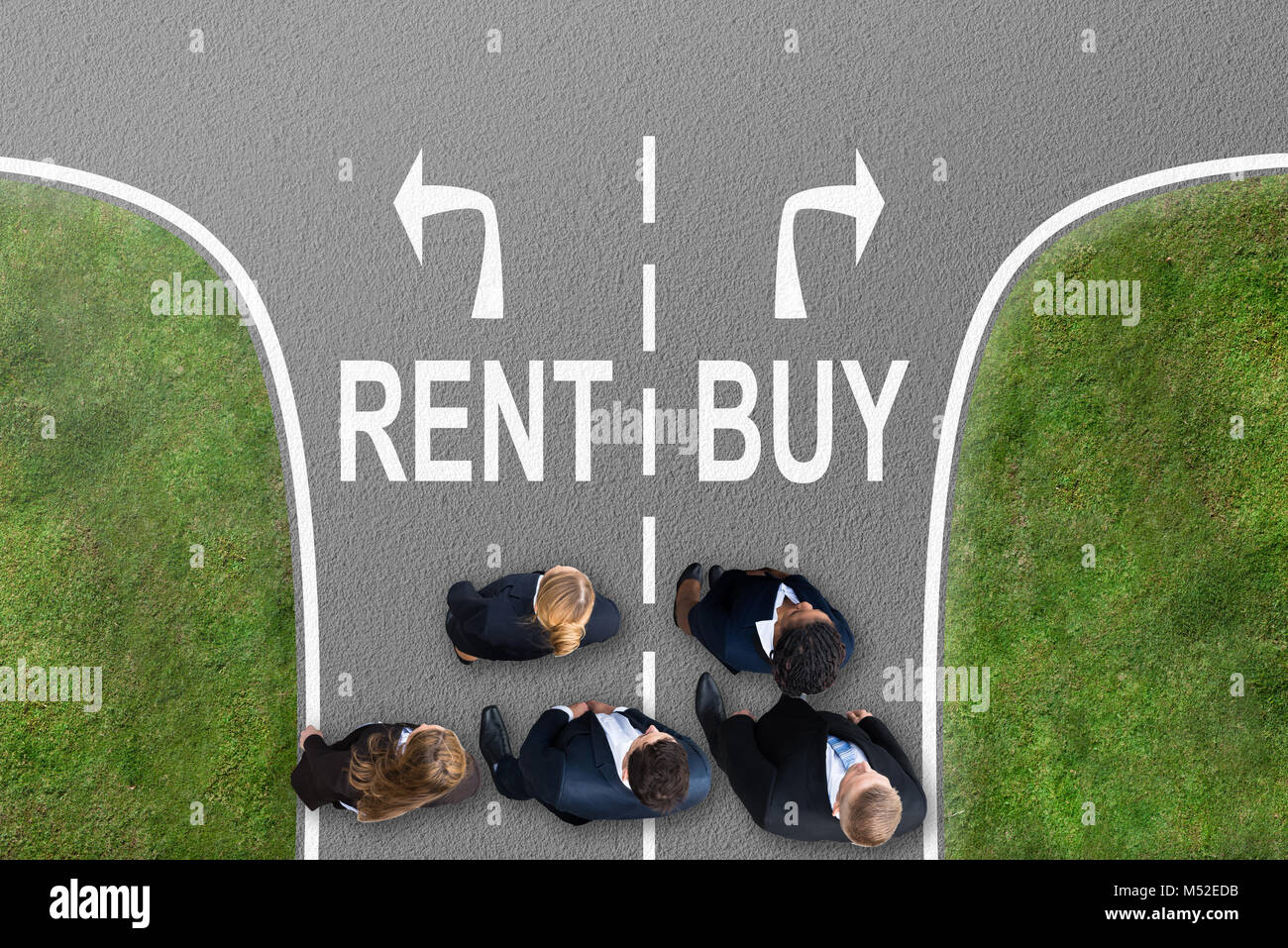 High Angle View Of Businesspeople Standing Near Arrows Showing Rent And Buy Directions Stock Photo