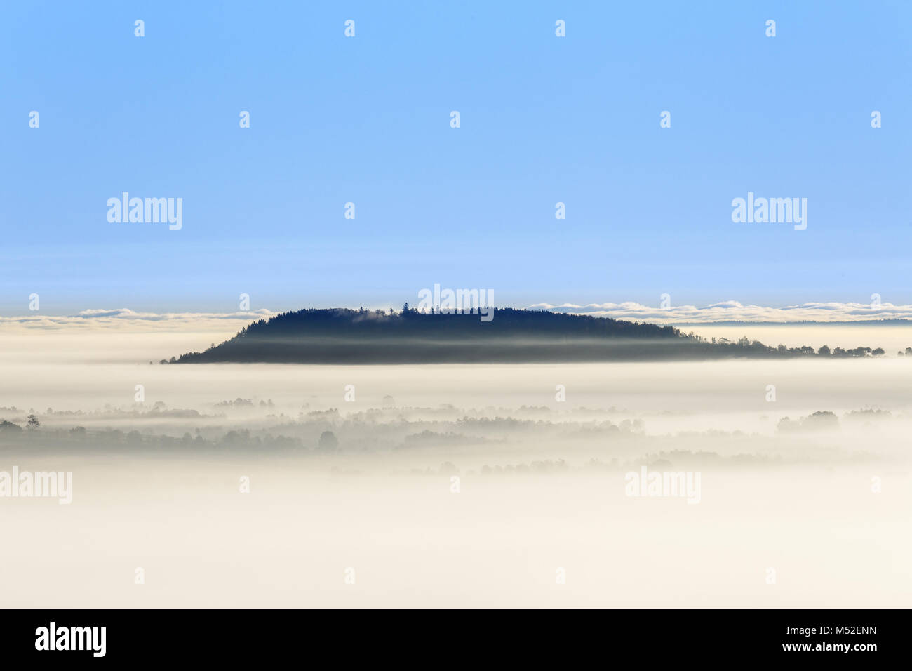 Foggy morning view with a mountain above the fog Stock Photo