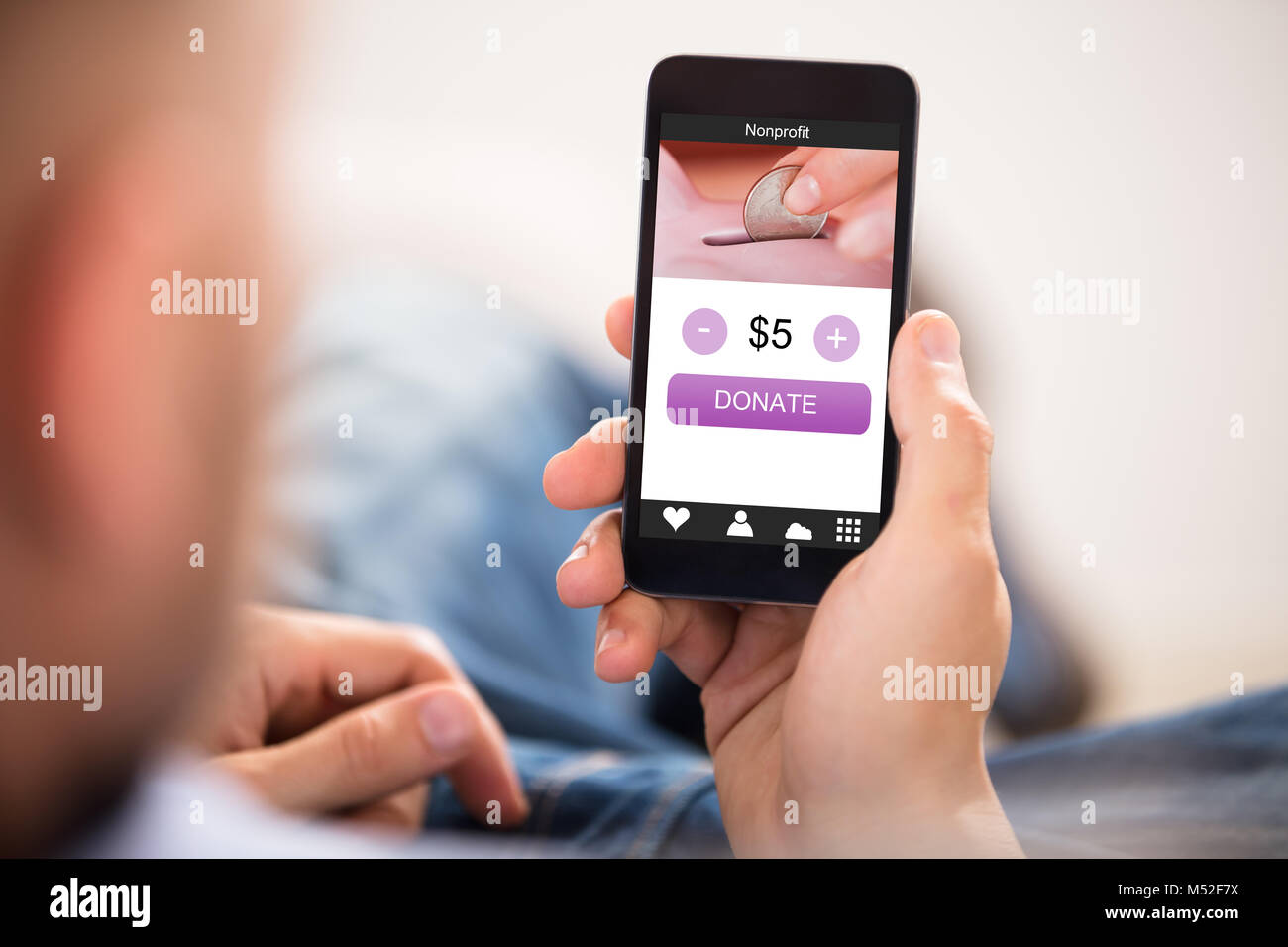 Person S Hand Holding Mobile Phone With Donation App On Screen Stock Photo Alamy