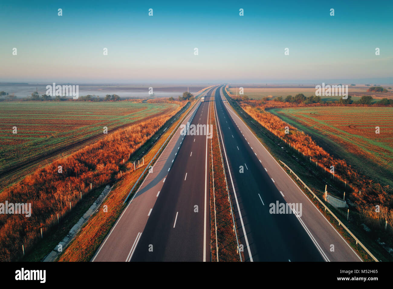 Aerial view of highway with forest and fields in fog Stock Photo - Alamy