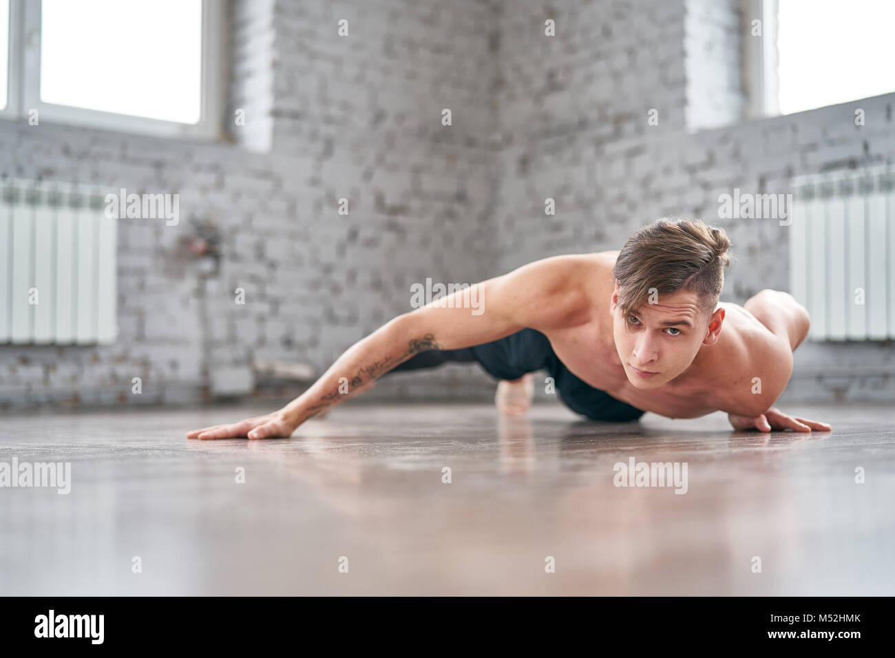 Athletic young man doing push ups on the floor Stock Photo - Alamy