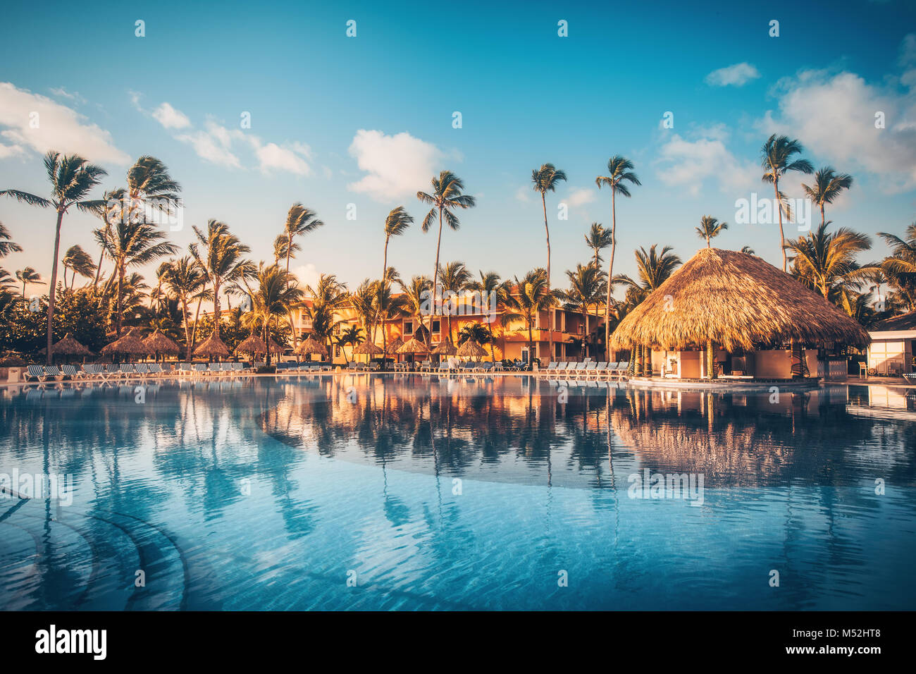 Tropical swimming pool and palm trees in luxury resort Stock Photo - Alamy