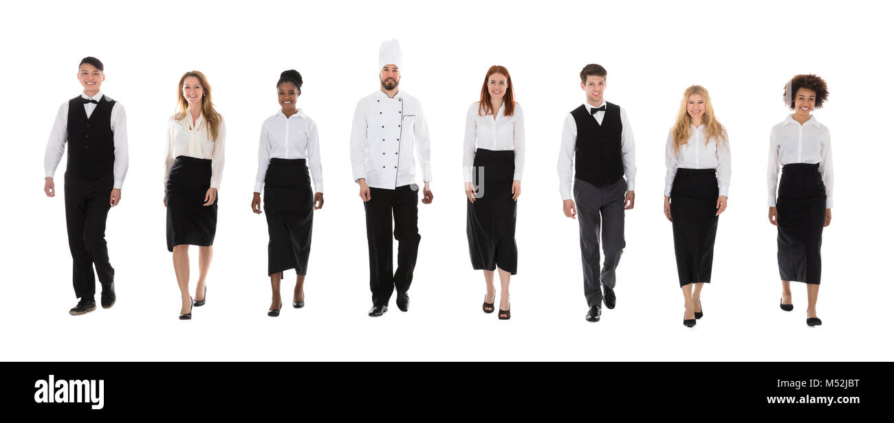 Team Of Happy Restaurant Staffs In Uniform Walking Over White Background Stock Photo