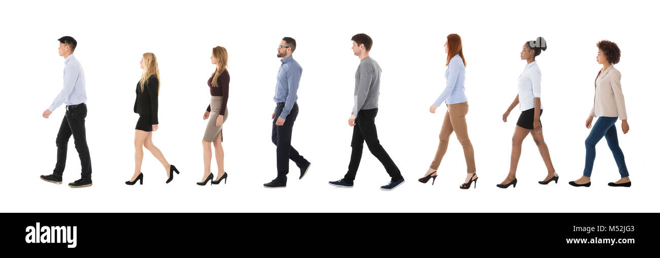 Group Of Businesspeople Walking In A Line Over White Background Stock Photo