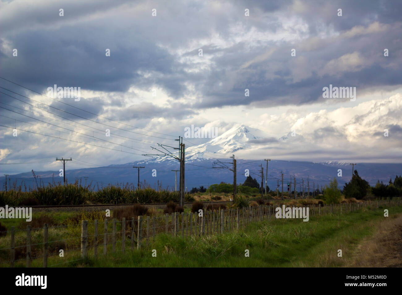 Stunning New Zealand landscape with Mount Ngauruhoe covered in snow and a cloudy dramatic sky. Stock Photo