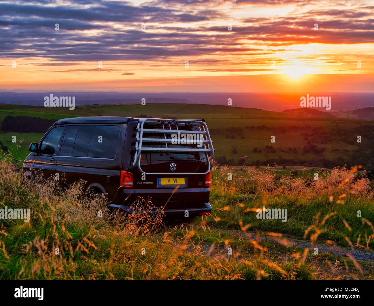 VW California camper van parked up for the night at a free glamping location the occupants enjoying the lovely sunset during near Pym's Chair Car Park Stock Photo