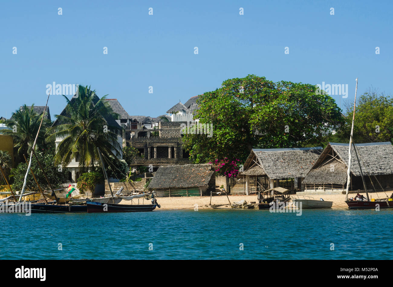 Traditional Swahili-style home on the Lamu Island waterfront, with boats at anchor in the water in front of it. Kenya, East Africa. Stock Photo