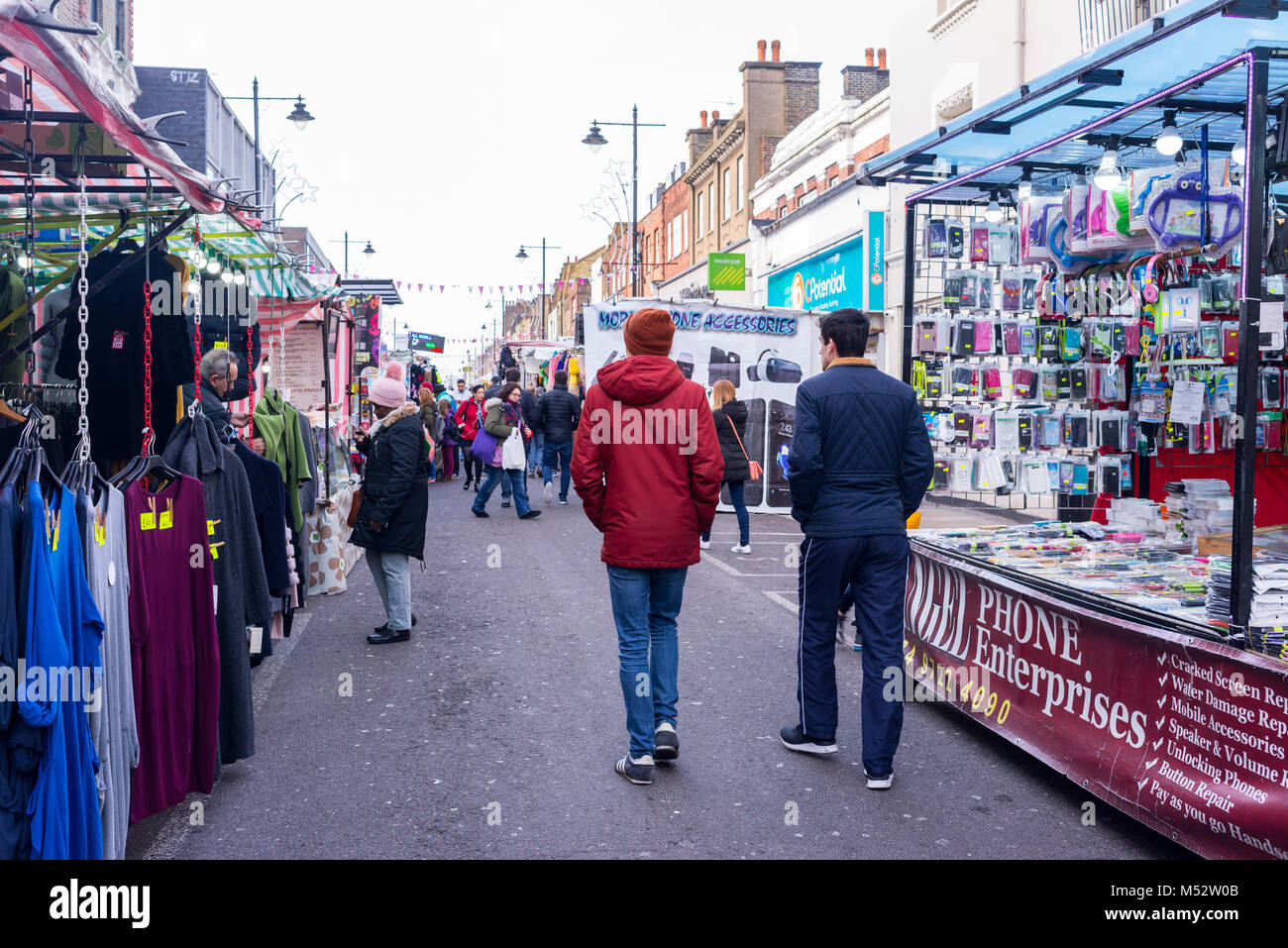 People walking and shopping around several stalls at the Chapel Market, a daily street market in Angel, Islington, North London, UK. Stock Photo
