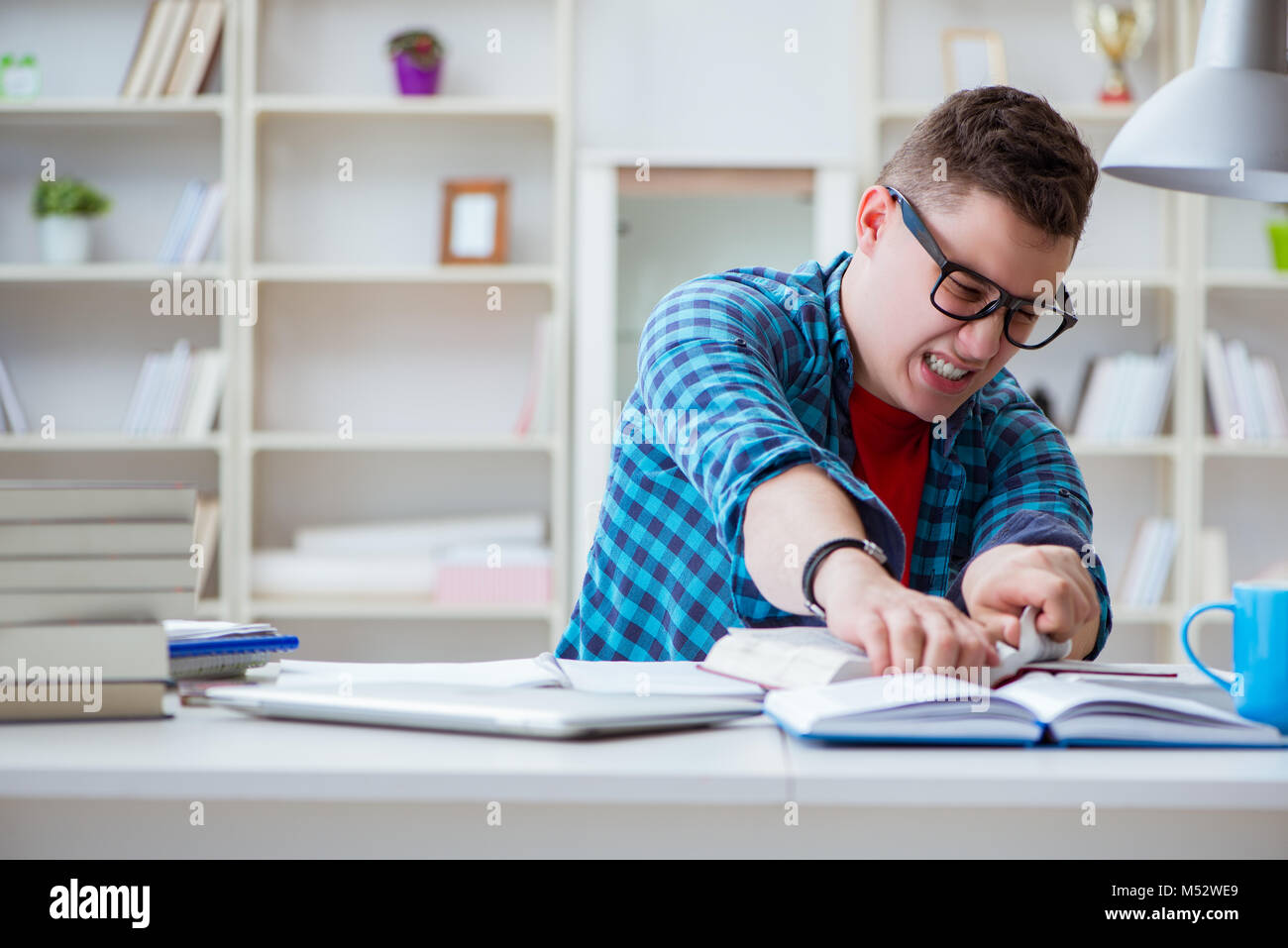 Student Preparing Young teenager preparing for exams studying at a desk indoors Stock ...