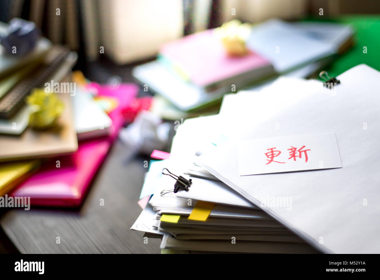 Renew; Stack of Documents. Working or Studying at messy desk. Stock Photo