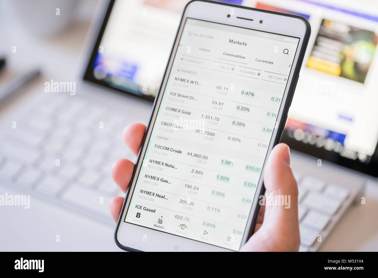 Checking commodity prices on a smartphone Stock Photo