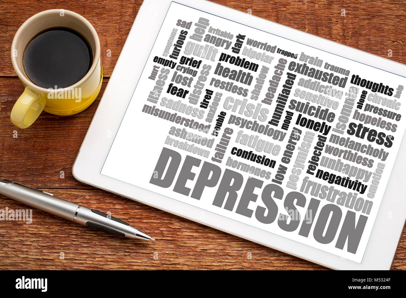 depression word cloud on a  digital tablet with a cup of coffee Stock Photo