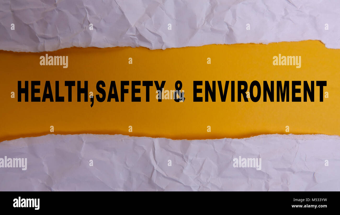 HEALTH, SAFETY AND ENVIRONMENT CONCEPT text at plain torn paper. Stock Photo