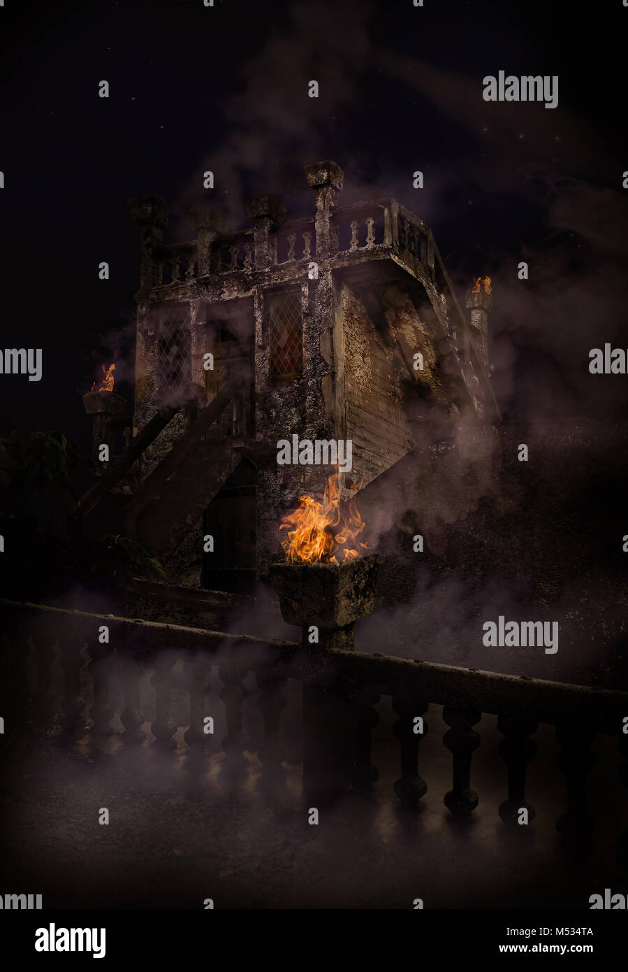 Eerie castle or watch tower at night with fire turrets and smoke Stock Photo