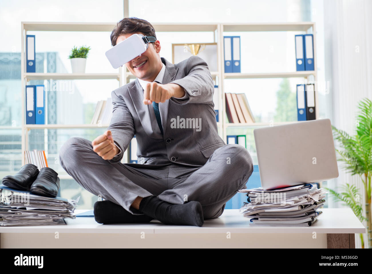 Businessman with VR virtual reality glasses in office Stock Photo - Alamy