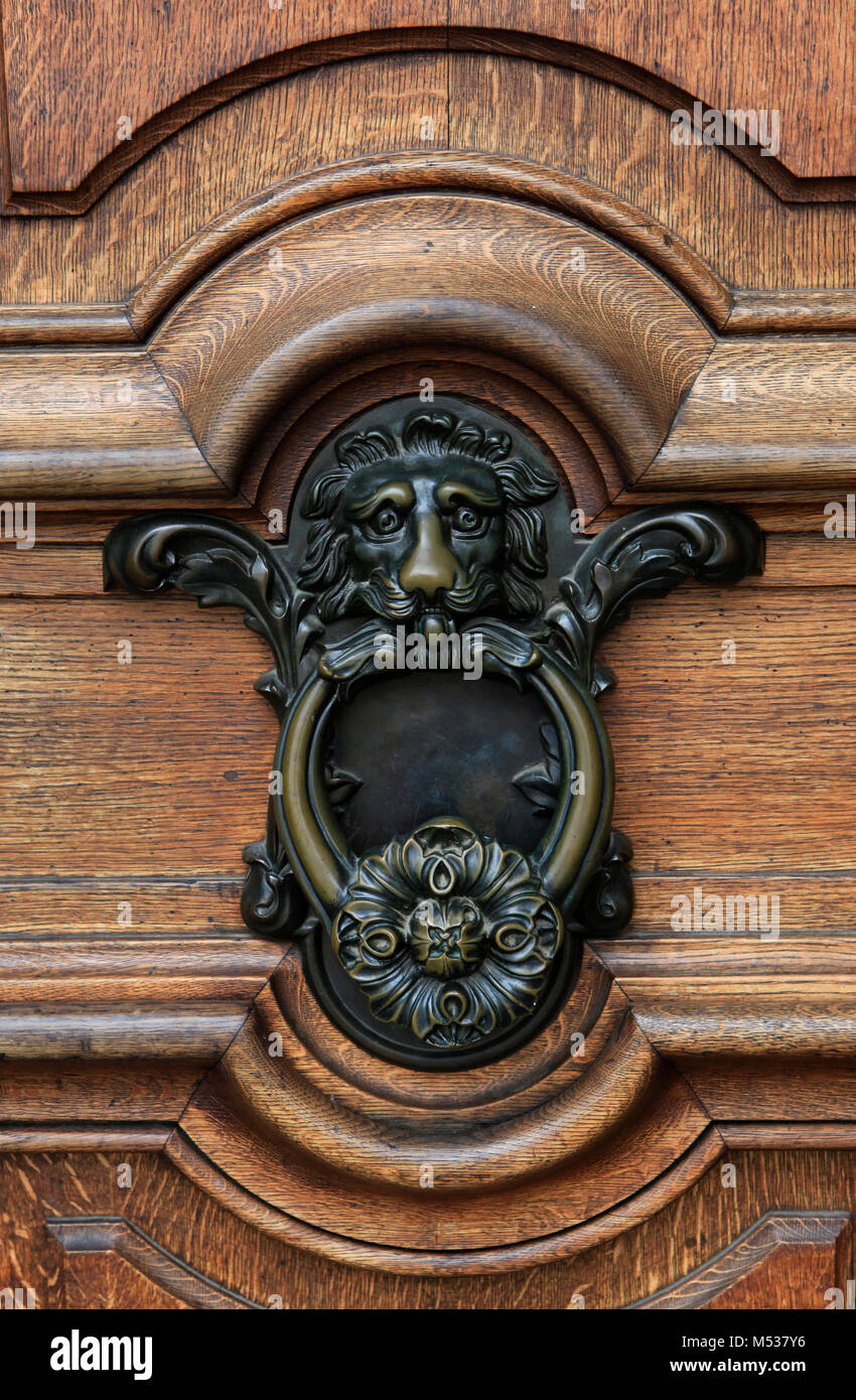 The pattern of weathered wood and an cast-iron door knocker - Lion's head  door knocker in Dresden on the Elbe River in Germany. Photo by Dennis Brack Stock Photo