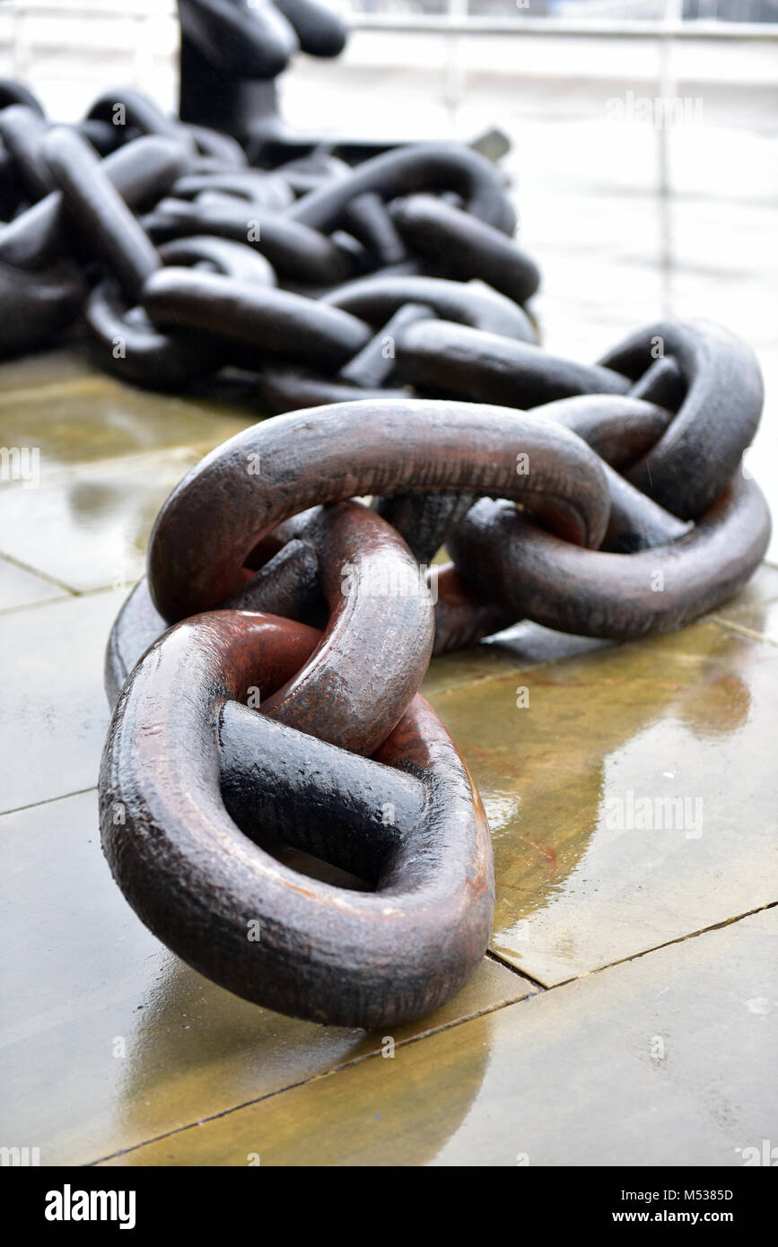 A large metal industrial sized ships anchor chain with links and