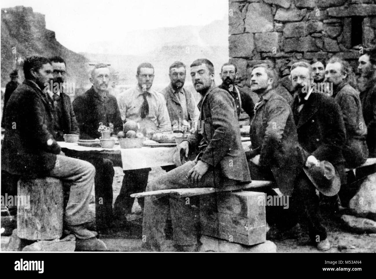THE STANTON EXPEDITION CREW- CHRISTMAS DINNER AT LEES FERRY. L TO  R: STANTON, NIMS, EDWARDS, TRAVERS, BALLARD, GIBSON, KANE, BROWN, TWINING, HOUGE, MCDONALD, HISLOP. 1889.     Grand Canyon Nat Park Historic River Photo. Stock Photo