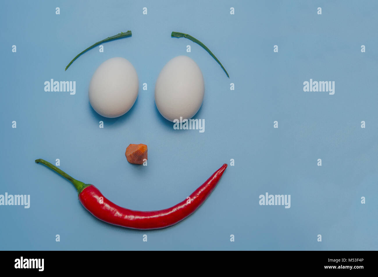 happy easter emoji from eggs, pepper, carrot and aloe on a blue background  Stock Photo - Alamy