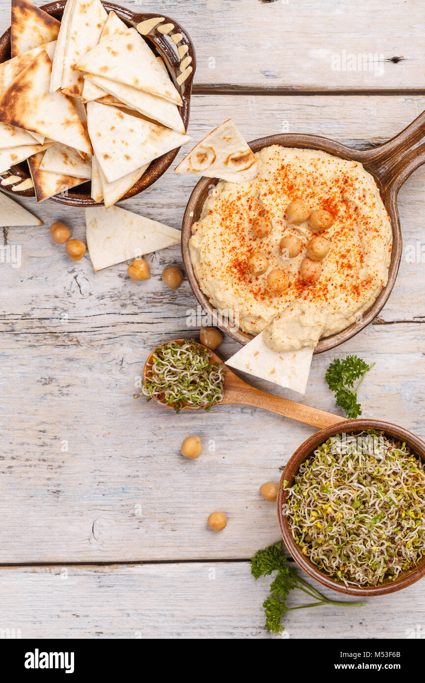 Hummus, chickpea dip, with pita bread and broccoli sprout Stock Photo