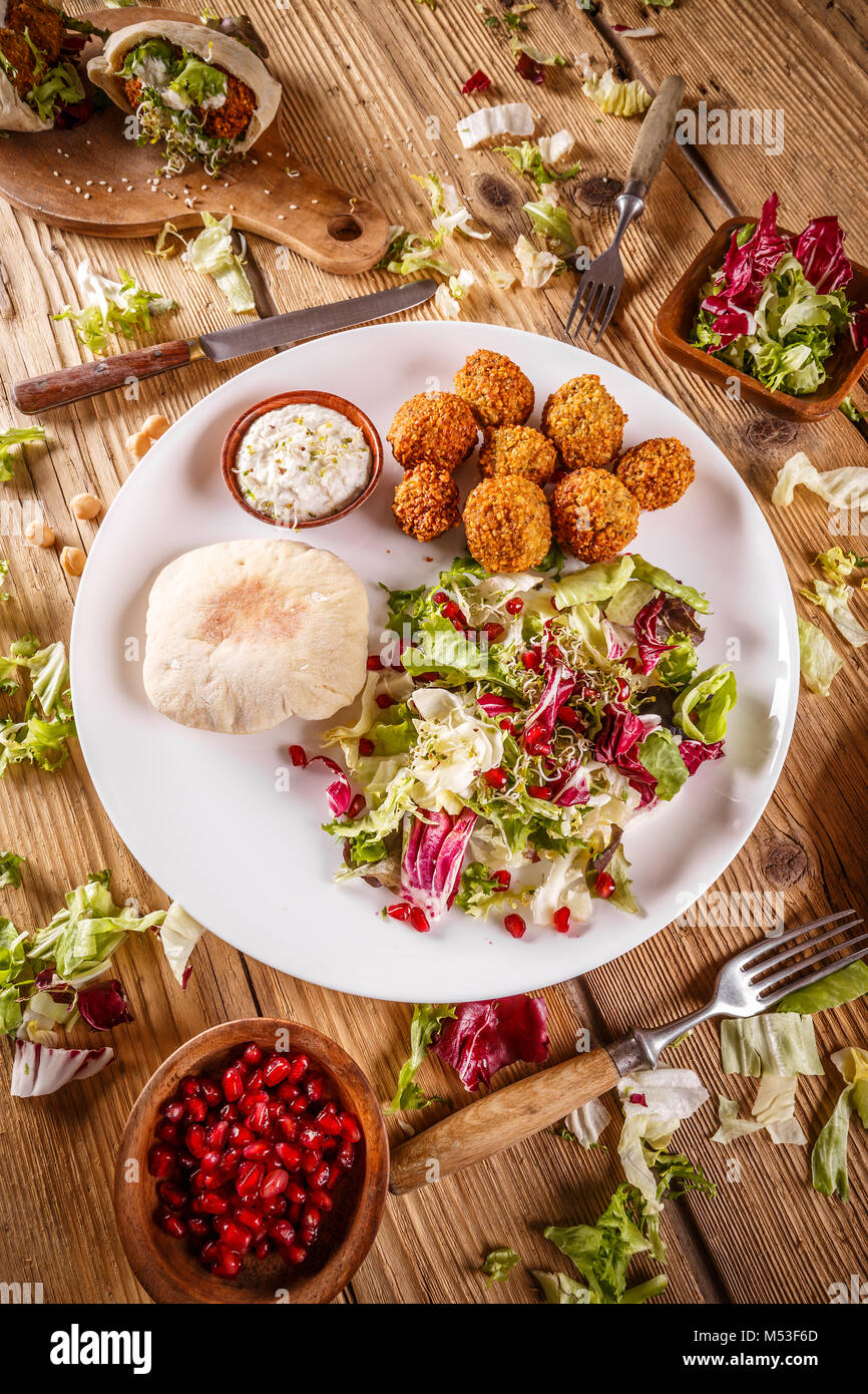 Plate of falafel with pita bread and tahini sauce on wooden table. View from above Stock Photo