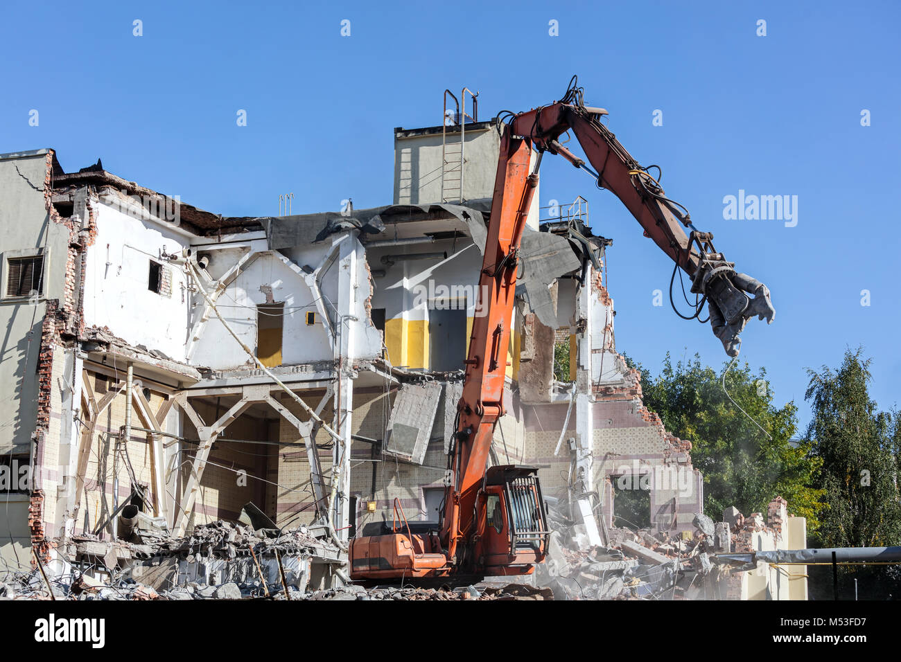 excavator with hydraulic shears on construction site. dismantling building. Stock Photo