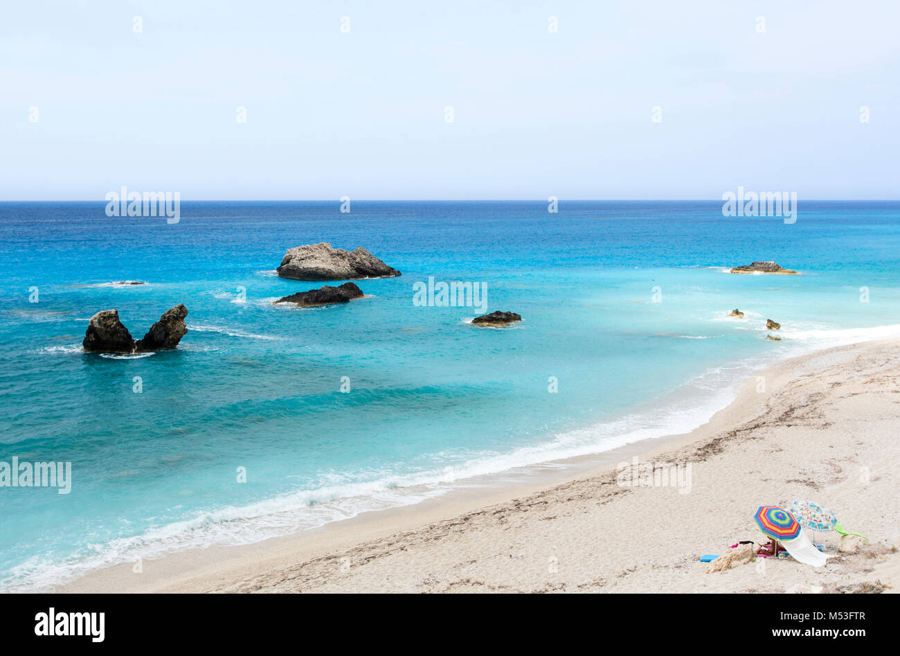 Turquoise waters of Kathisma Beach at Lefkada Island, Greece, with very few tourists enjoying the beach. Stock Photo