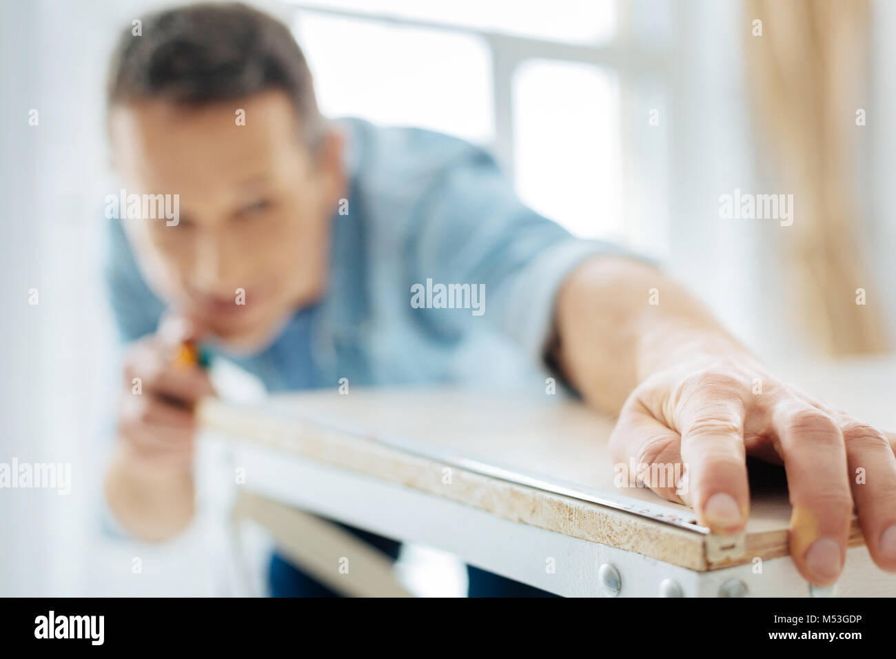Close up of young man using a tape measure Stock Photo