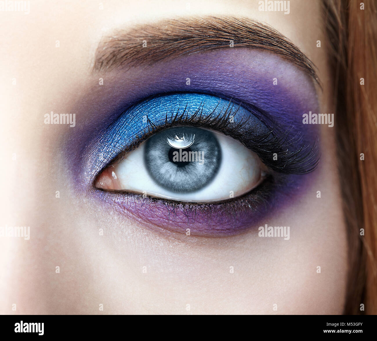 Closeup of female eye with blue and violet makeup Stock Photo