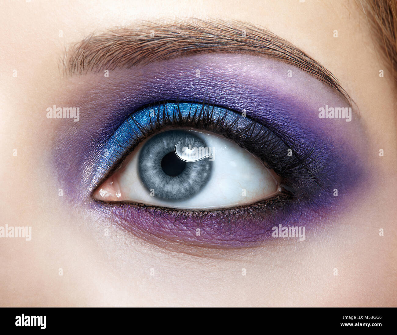 Closeup of female eye with blue and violet makeup Stock Photo
