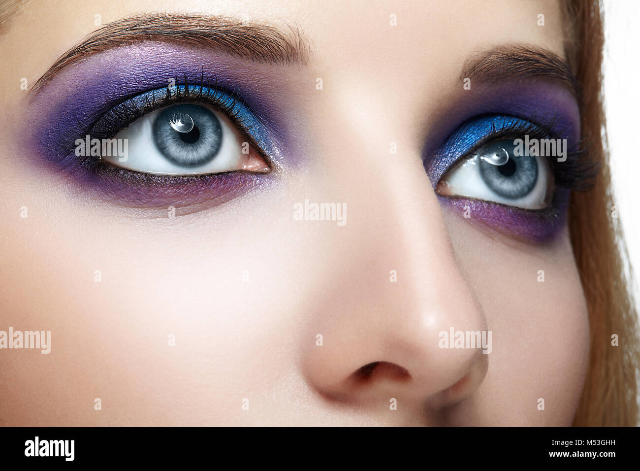 Closeup shot of female face eye with blue and violet makeup Stock Photo