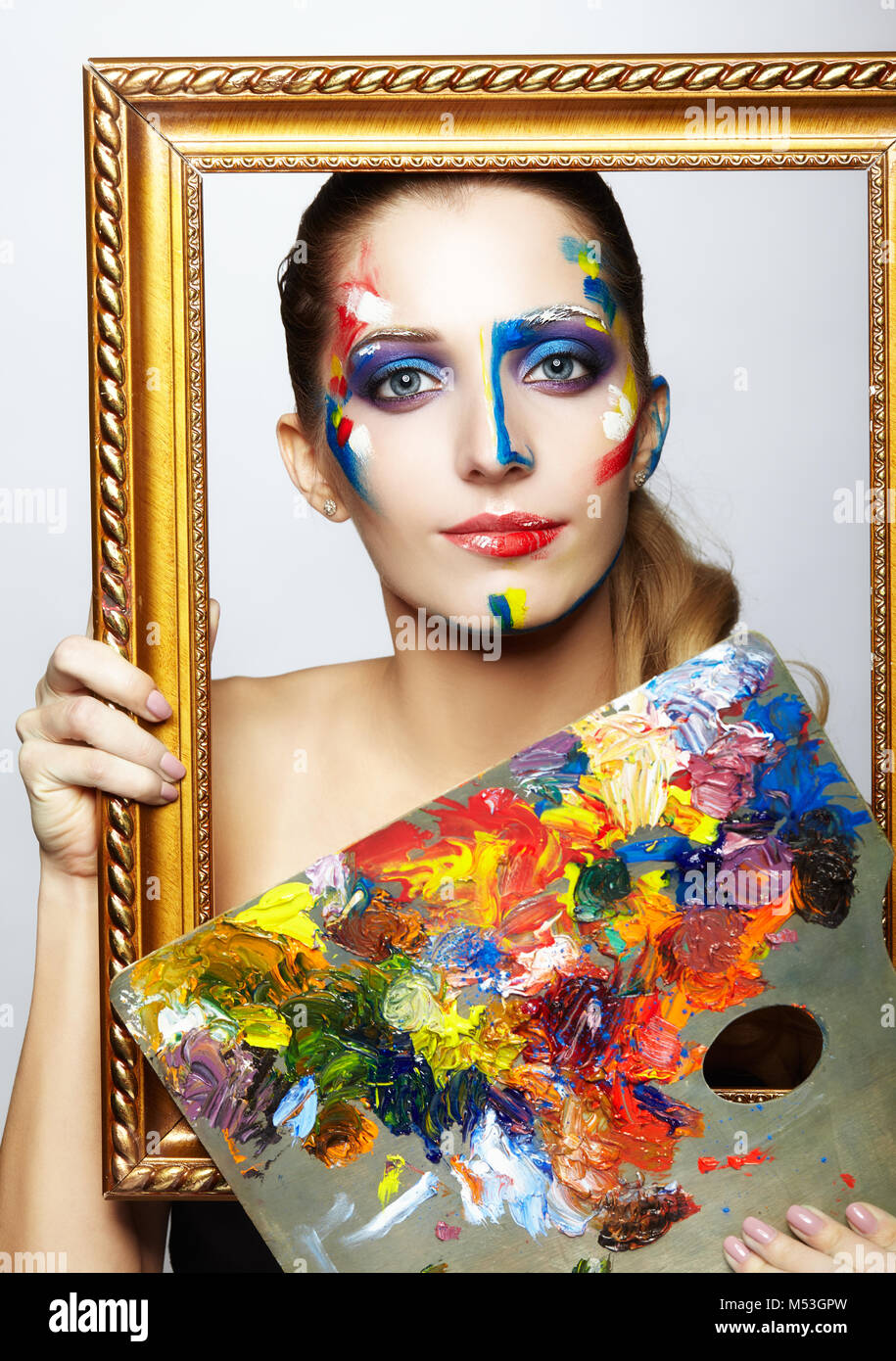 Young woman painter in golden frame with color palette in hand Stock ...