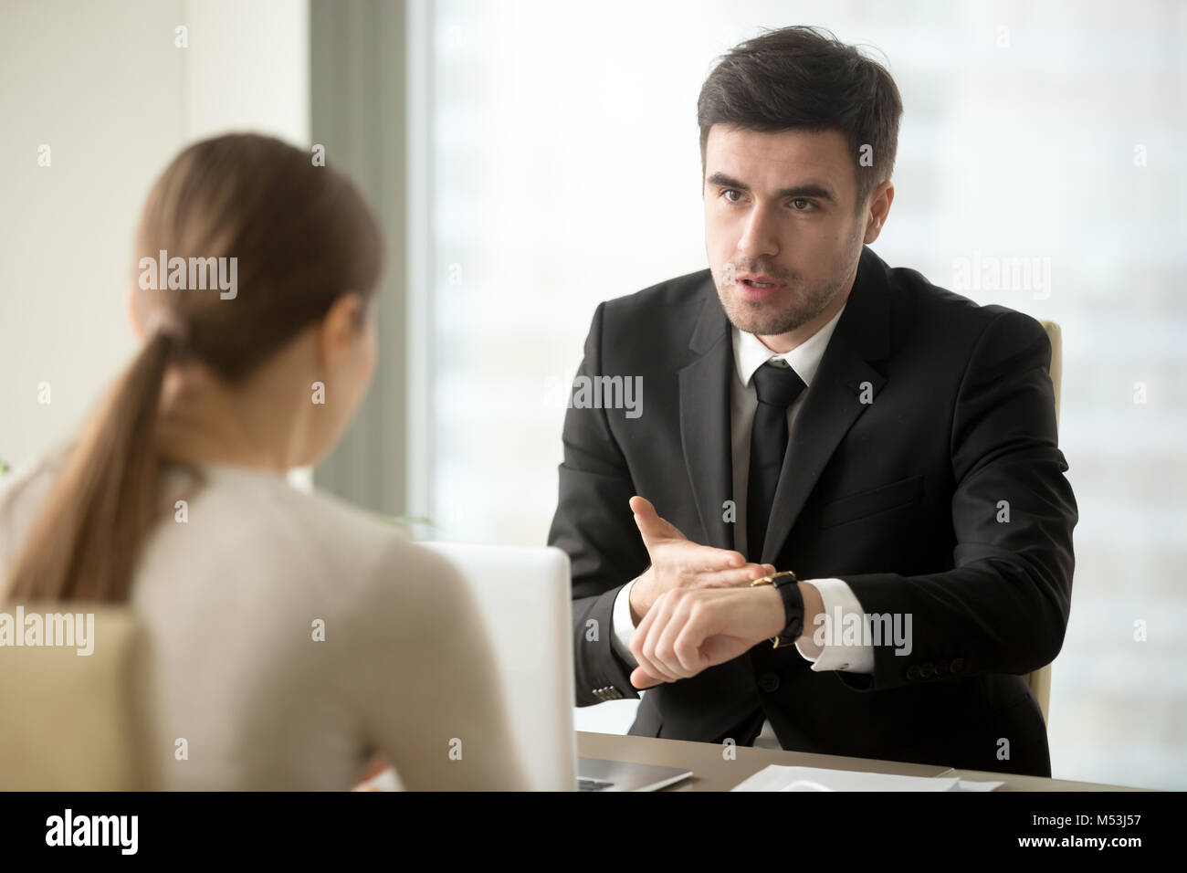 CEO asking female employee about reason of work delay  Stock Photo