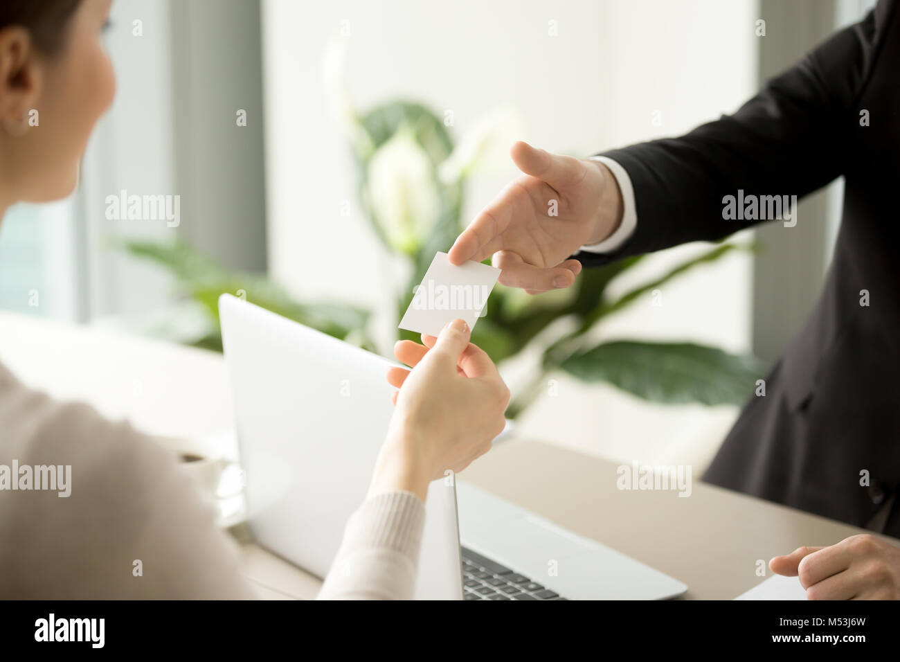 Businessman giving business card to businesswoman Stock Photo