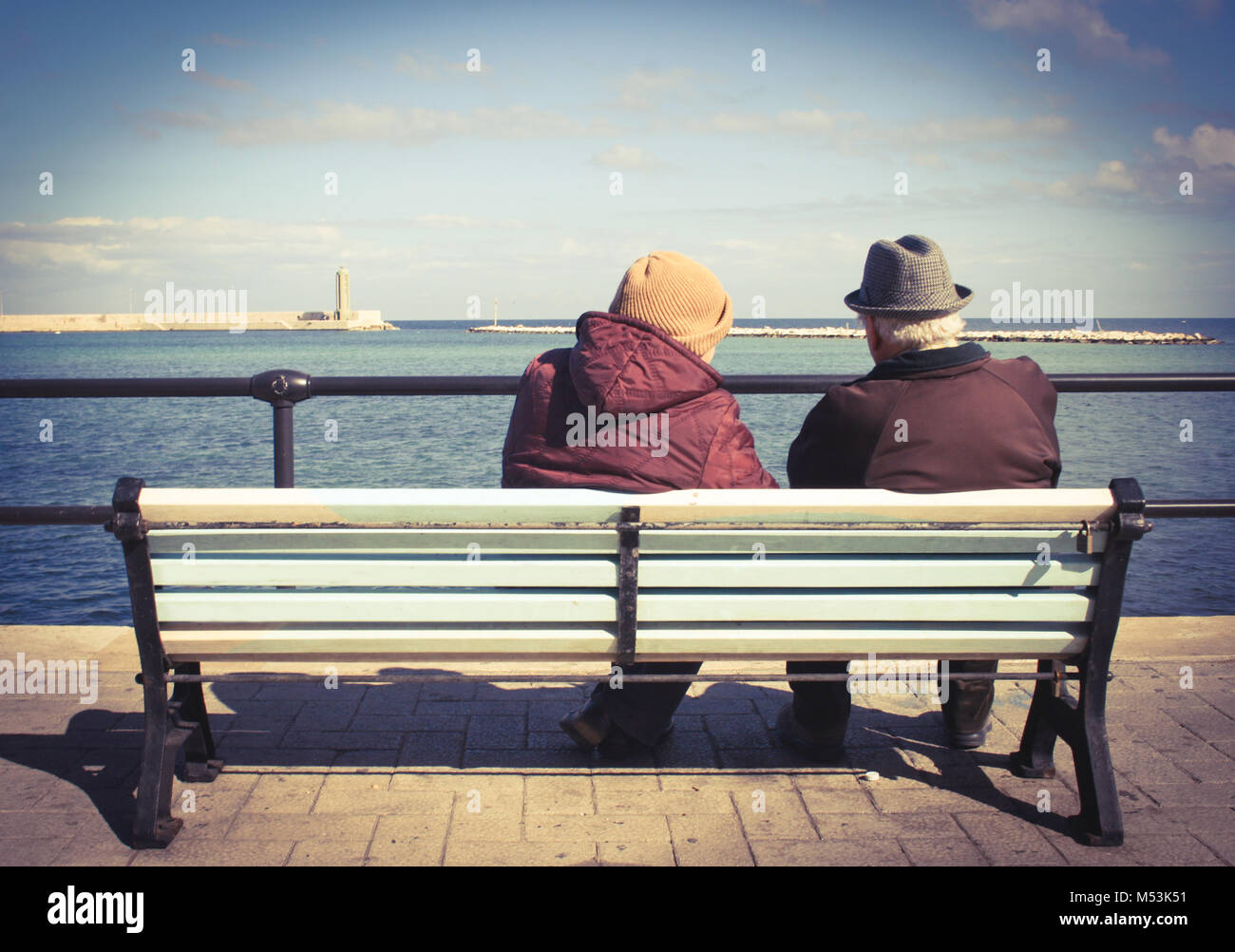 Elderly lovely couple on a bench by the sea Stock Photo