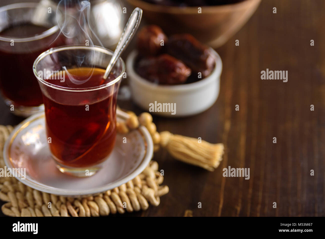 Dried dates fruits with tea for iftar. Prayer beads on background Stock Photo