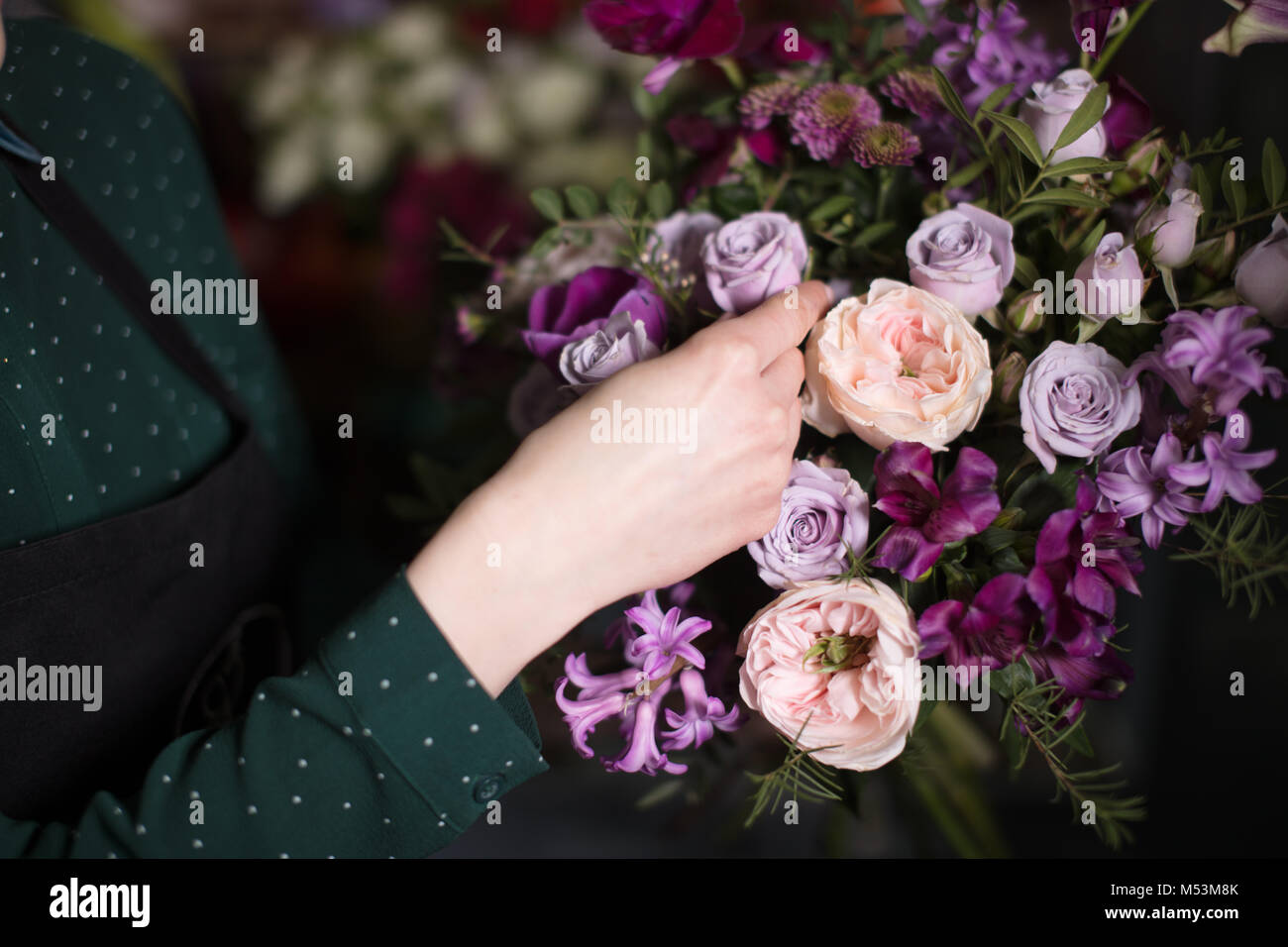 young vendor touching beautiful roses at shop Stock Photo Alamy