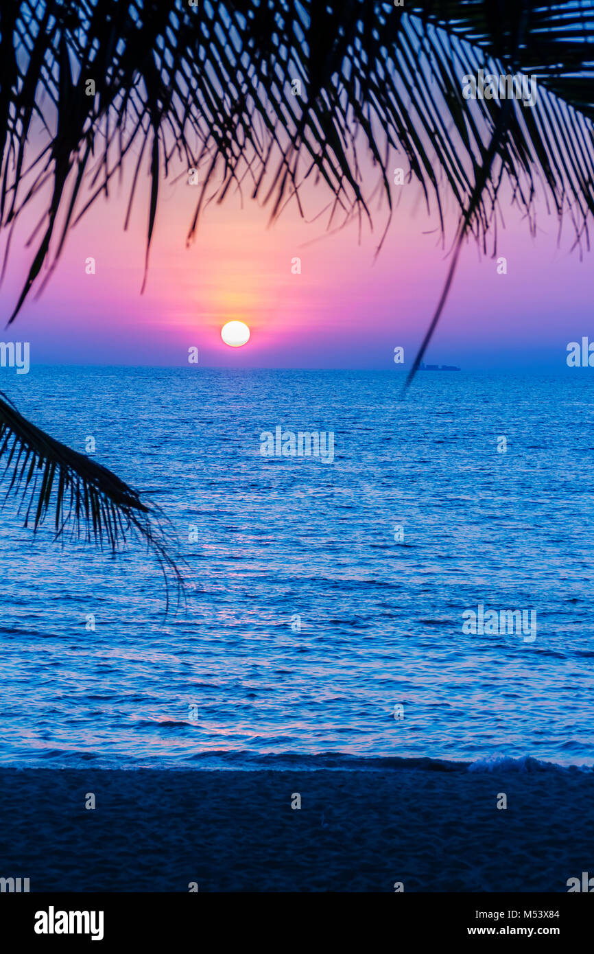 Beautiful sunset over the sea, view from the beach. Round and bright sun in  dusk over calm sea with blurred dramatic sky background. Silhouette cocon  Stock Photo - Alamy
