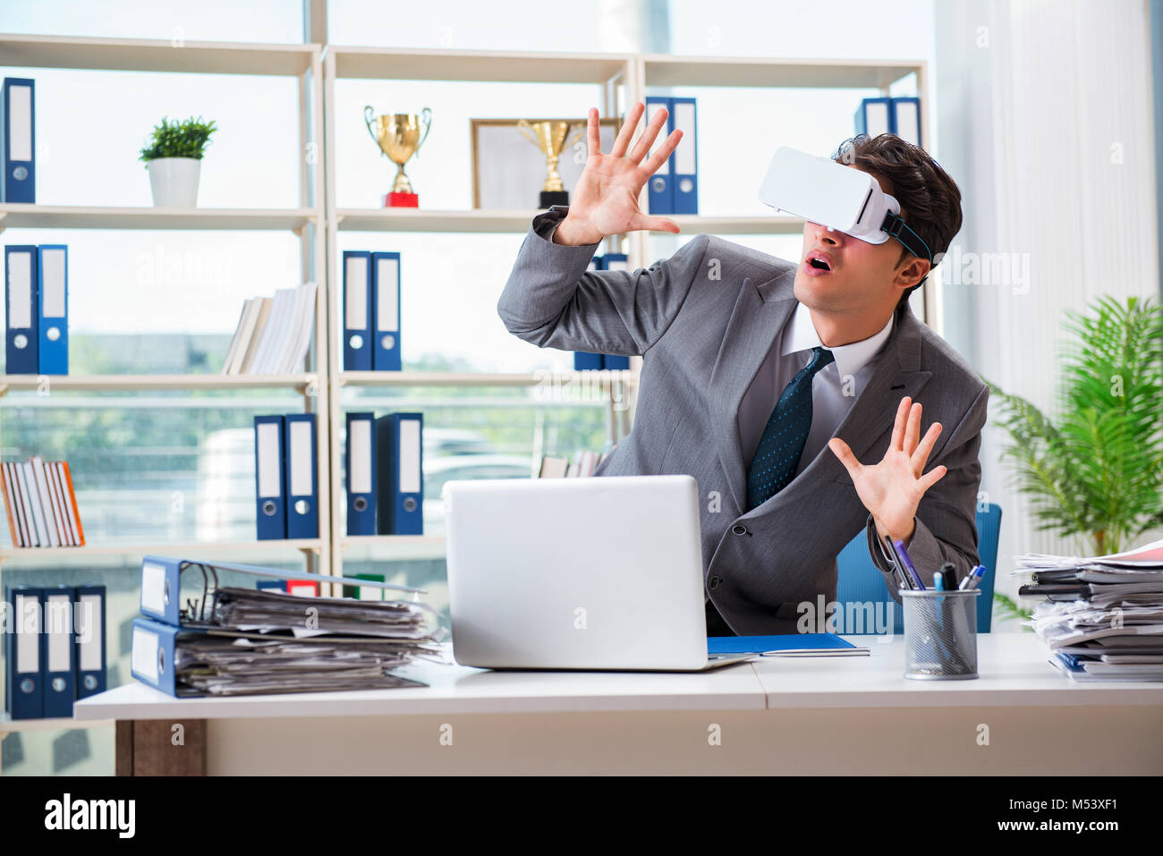 Businessman with VR virtual reality glasses in office Stock Photo - Alamy