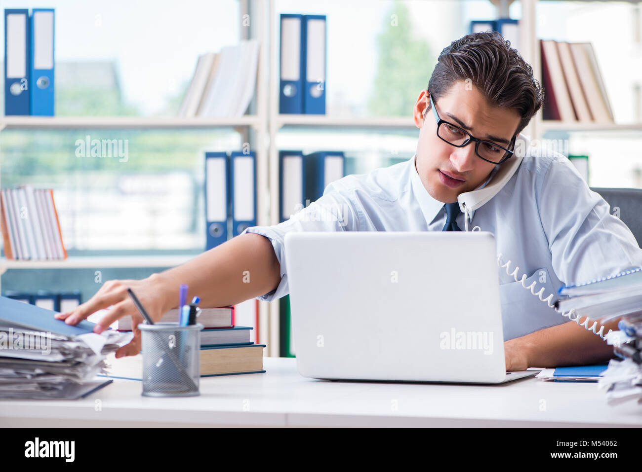 Excess Paperwork Businessman with excessive work paperwork working in office Stock Photo ...