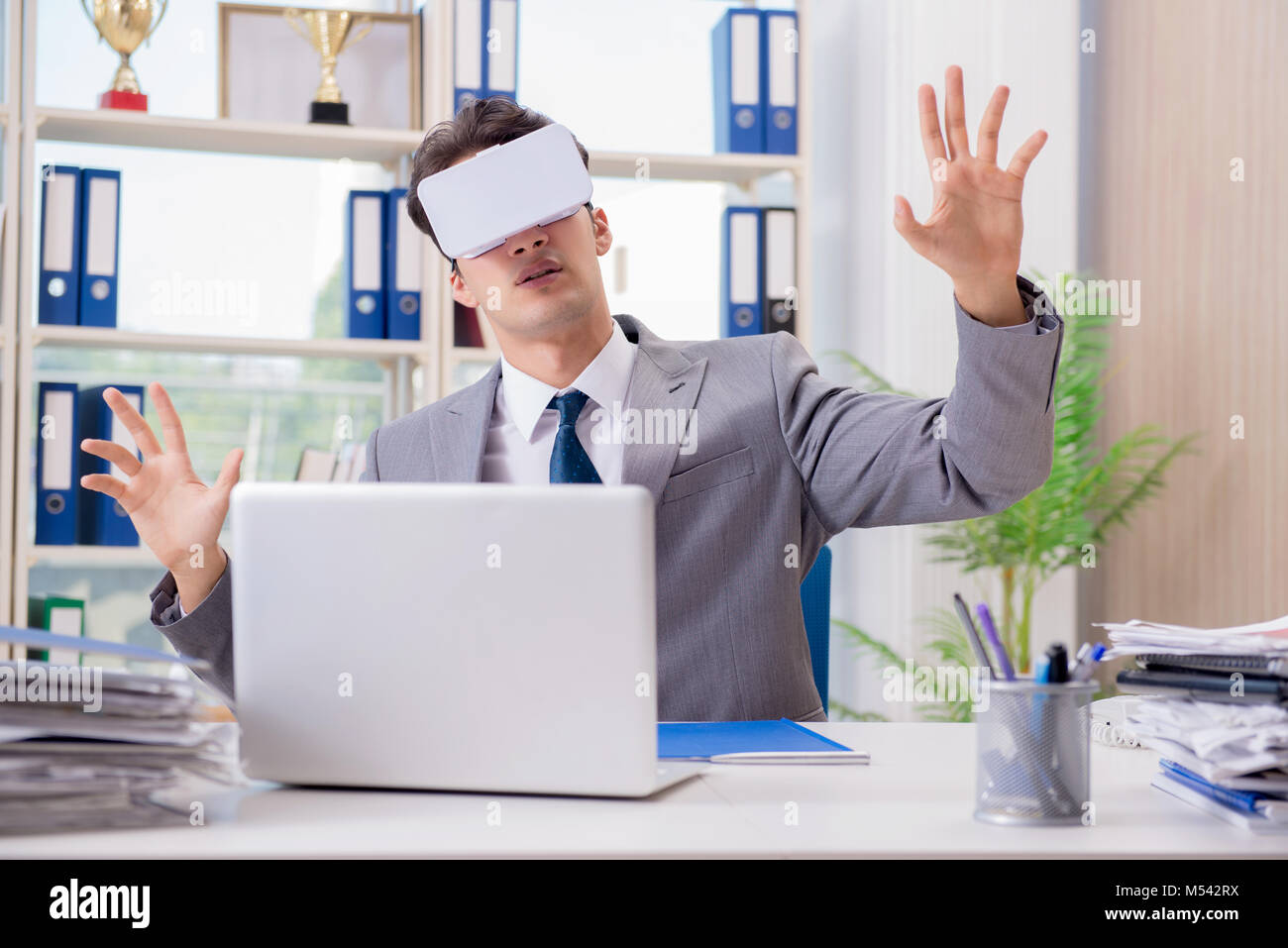 Businessman with VR virtual reality glasses in office Stock Photo - Alamy