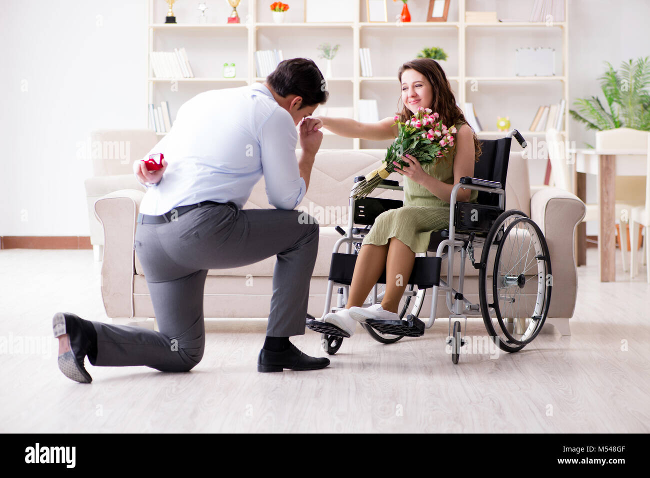 Man making marriage proposal to disabled woman on wheelchair Stock Photo