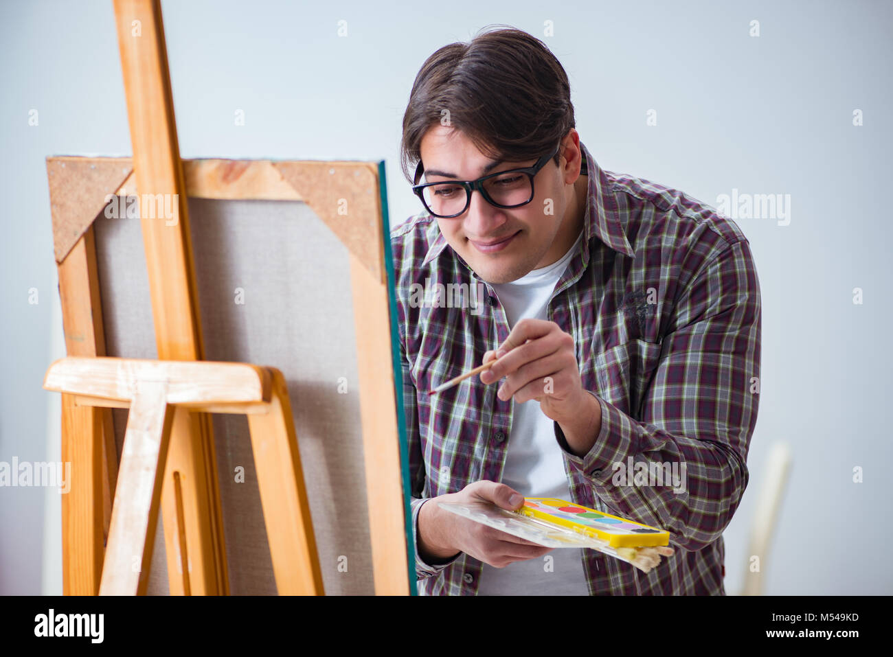 Young male artist drawing pictures in bright studio Stock Photo - Alamy